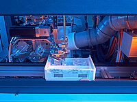 Automated machine processing glass lenses in a production box during the manufacturing process