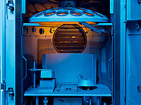 Inside view of a vacuum coating machine with mounted optical lenses.