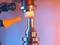 Close-up of precision laboratory equipment with a probe engaging a small sample