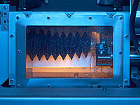 View through an inspection window into the inner working area of an automated industrial machine