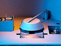 Close-up of industrial machine components with circular housing and lever arm