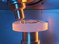 Close-up of laboratory machine with a precision tool processing a cylindrical sample