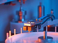 Close-up of industrial machine with sensor arm positioned over circular component