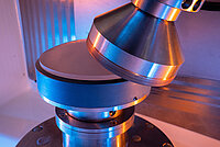 Laboratory equipment with a conical tool applying pressure to a cylindrical sample