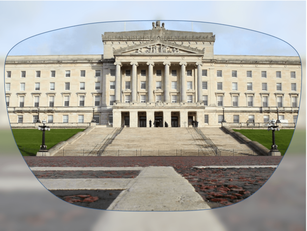 View through a pair of glasses showing a large neoclassical government building with columns and wide stone steps.