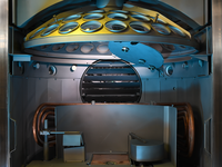 Inside view of a vacuum coating chamber with multiple mounted optical lenses.
