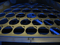 Close-up of a circular wafer holder with multiple empty slots inside semiconductor processing equipment.