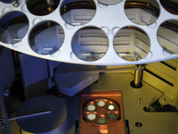 Interior view of a semiconductor processing machine with wafer holder and multiple slots for wafers.