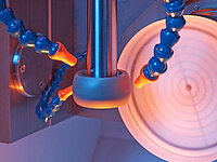 Close-up of a Satisloh GI ball segment tool used in precision optics grinding.