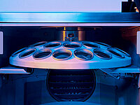 Close-up of multiple optical lenses arranged in a vacuum coating machine.