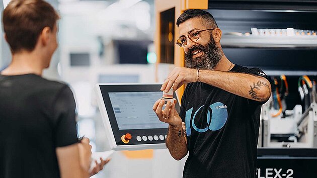 Instructor demonstrating industrial machine to two people in a training session