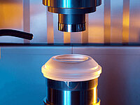 Precision laser tool processing a mounted cylindrical sample in a laboratory machine