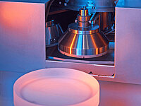 Close-up of a Satisloh GI tool changer used in precision optics manufacturing.