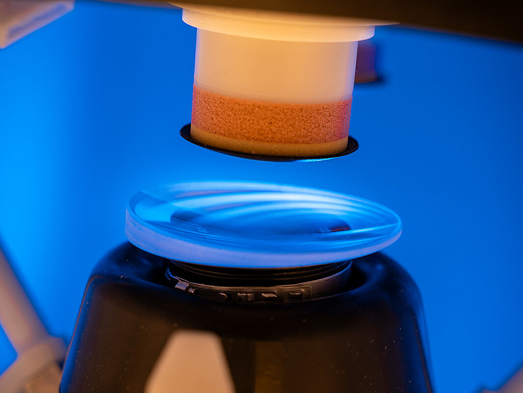Satisloh NEO-Flex lens processing machine shown in an industrial environment, highlighting the compact design and precision technology for ophthalmic lens manufacturing.