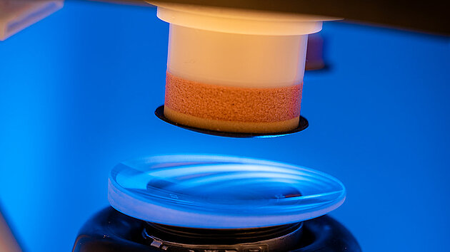 Satisloh NEO-Flex lens processing machine shown in an industrial environment, highlighting the compact design and precision technology for ophthalmic lens manufacturing.