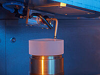 Laboratory probe positioned above a cylindrical sample on a metallic holder