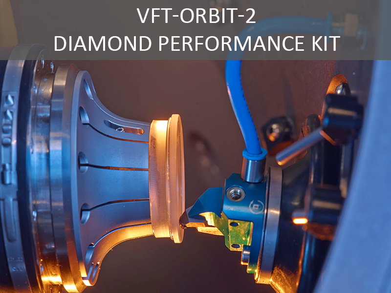 Machine processing a glass lens between two precision tools, with visible label ‘VFT-ORBIT-2 Diamond Performance Kit