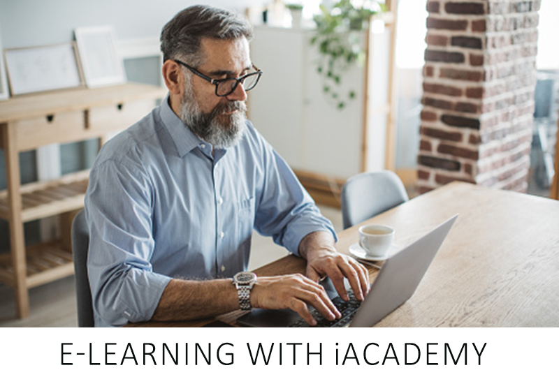 Man working on a laptop at home with text 'E-Learning with Academy