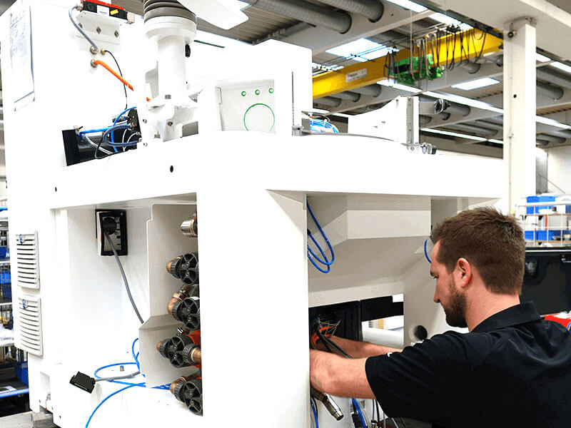 Technician working on a large industrial testing machine in a laboratory setting