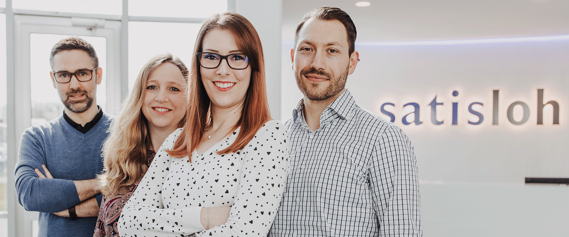 Satisloh employees smiling at the camera.