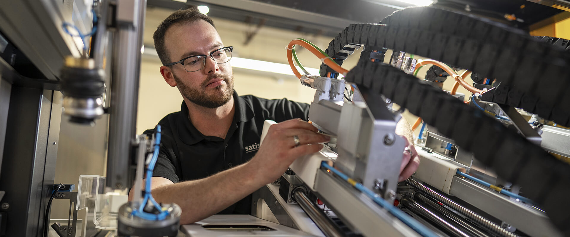 Technician inspecting and adjusting components inside an industrial machine