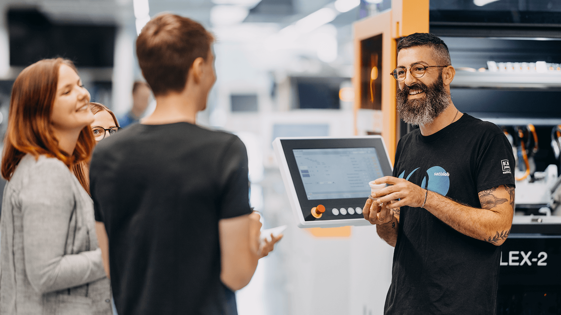 Instructor holding tablet and explaining industrial process to two participants
